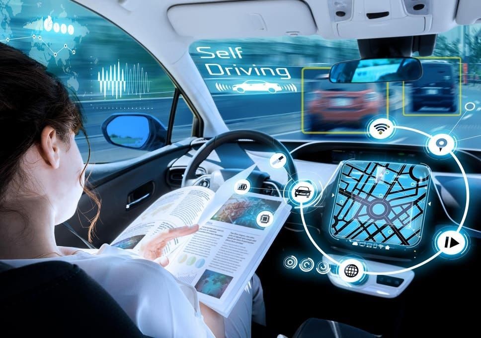 Woman reading a book inside a self-driving car with digital interface and holographic maps displayed.